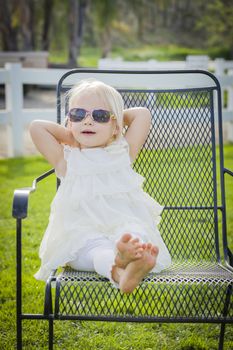 Cute Playful Baby Girl Wearing Sunglasses Outside at the Park.