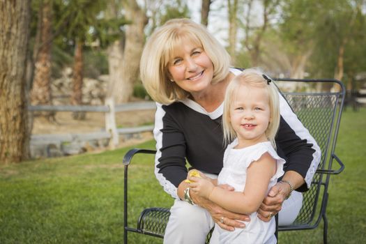 Affectionate Grandmother and Granddaughter Playing Outside At The Park.