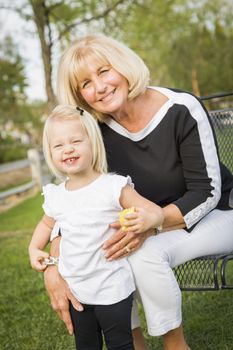 Affectionate Grandmother and Granddaughter Playing Outside At The Park.