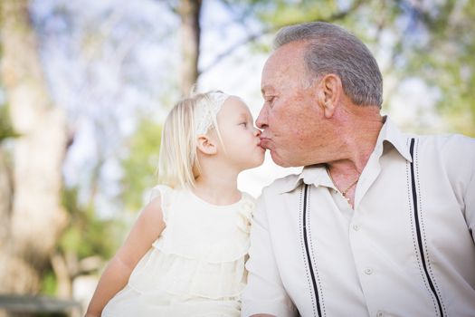 Loving Grandfather and Granddaughter Kissing Outside At The Park.