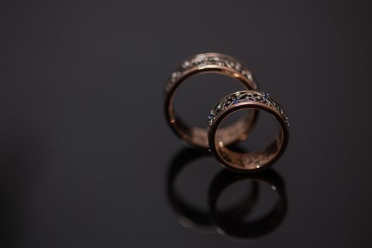 Two wedding rings in infinity sign on black background. Love concept.