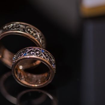 Two wedding rings in infinity sign on black background. Love concept.