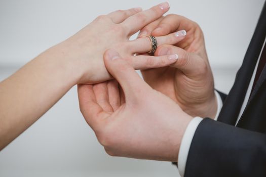 Marry me today and everyday, hands of a wedding heterosexual couple. Groom put a ring on finger of his lovely wife.
