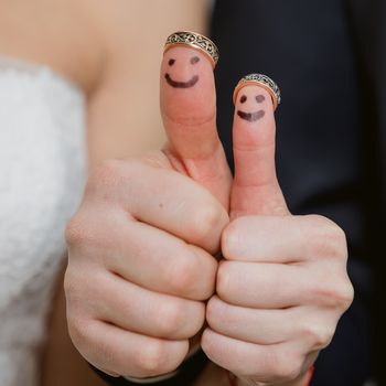 wedding rings on their fingers painted with the bride and groom, funny little people. conceptual idea