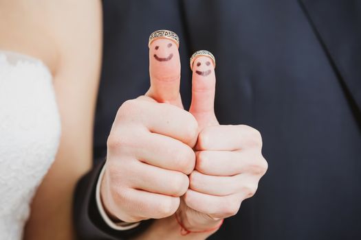 wedding rings on their fingers painted with the bride and groom, funny little people. conceptual idea