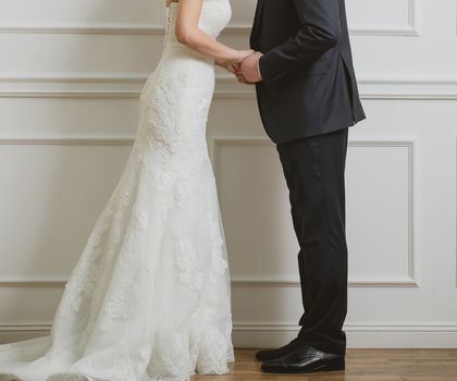 Elegant bride and groom posing together in studio on a wedding day