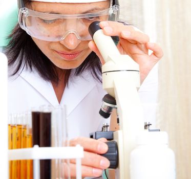 scientist looking into microscope at the lab, close up