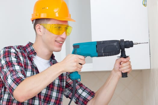 smiling worker in protective gloves and eyeglasses with rock-drill