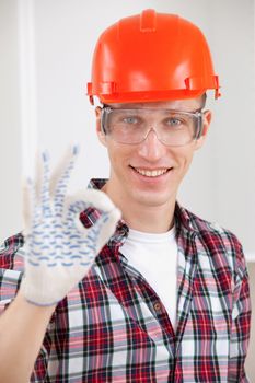 repairman making a perfect gesture with his gloved hand with focus to his face