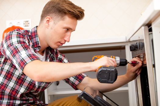 worker collects electric oven on the kitchen