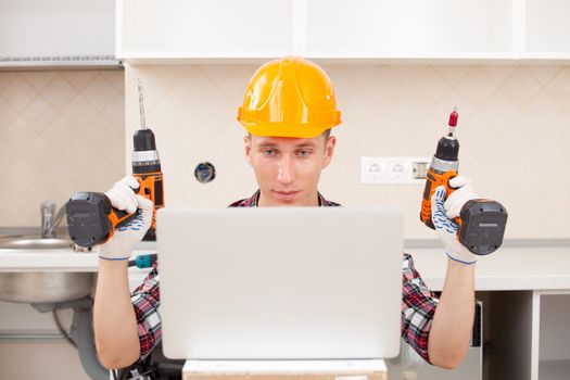 repairman with the screwdriver and drill near a computer