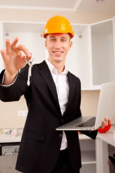 smiling engineer gives keys of new apartment