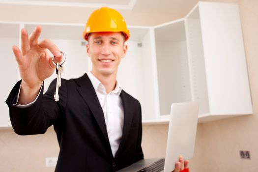 civil engineer with a laptop gives the keys to the apartment