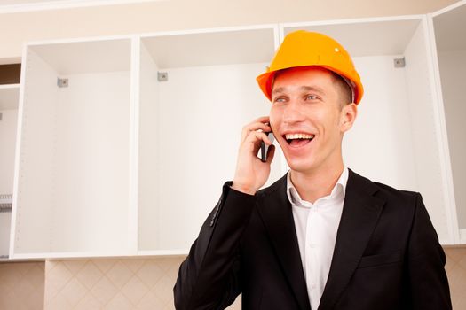 superintendent engineer talking on the phone in the interior of a new apartment