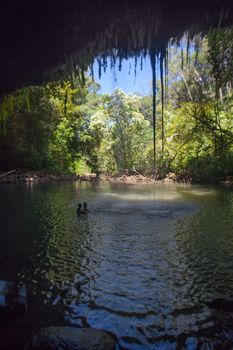 Couple in a grotto under waterfall near Hana Highway