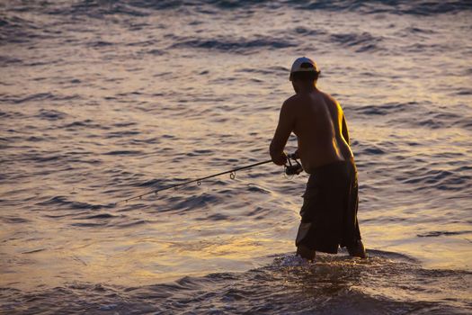 Silhouette of Hawaiian man fishing at Kihei Beach