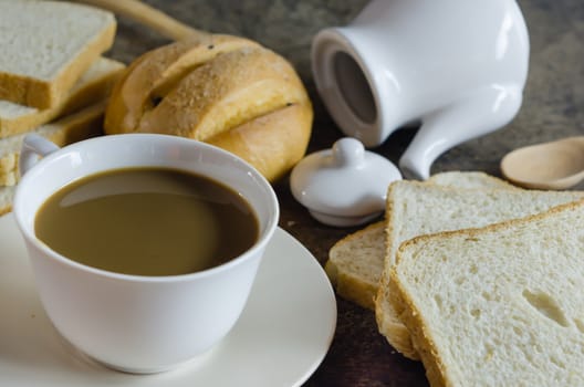 hot coffee with fresh bread on wooden  background  ,  still life