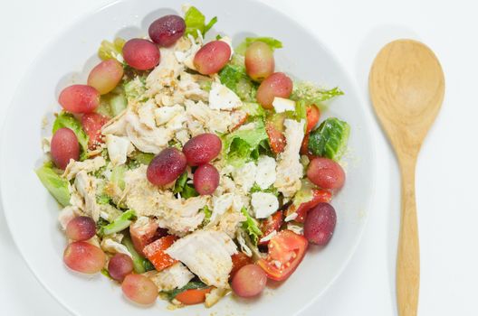 Mix salad with grapes and chicken on white dish