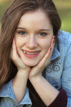 Close up of cute young woman with hands on cheeks