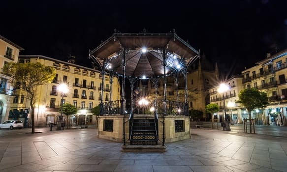 A solo gazebo in the Segovia market square at night.