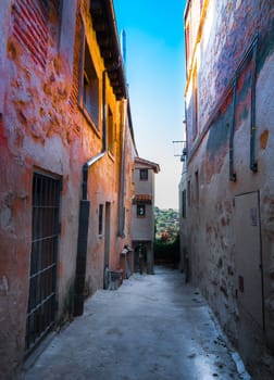 Morning color radiates from the alley walls in the streets of Segovia, Spain