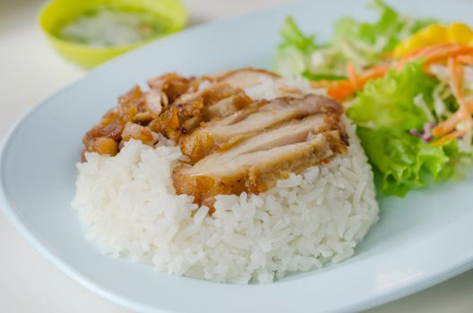 close up fried Chicken over steamed rice on plate