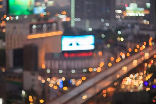 Abstract background of the night light trails with the modern building and traffic on highway, shallow depth of focus