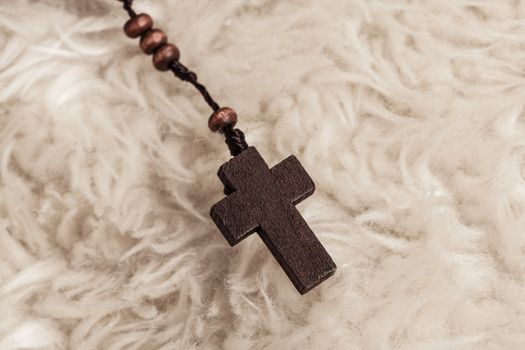 Christian cross necklace on sheep wool, Jesus religion concept as good friday or easter festival