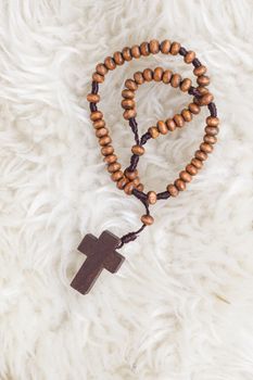 Christian cross necklace on sheep wool, Jesus religion concept as good friday or easter festival