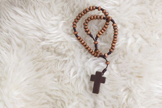 Christian cross necklace on sheep wool, Jesus religion concept as good friday or easter festival