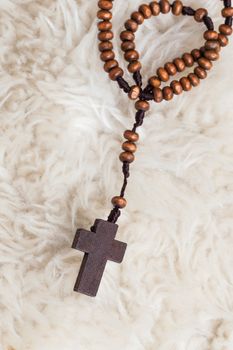 Christian cross necklace on sheep wool, Jesus religion concept as good friday or easter festival