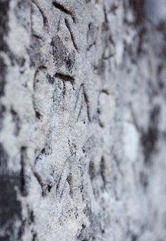 The surface of the old cross gravestone with engraved Old Church Slavonic inscriptions. Kyiv, Ukraine. Close up.