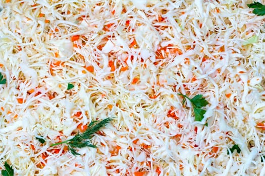 A delicious salad of fresh cabbage and carrots, garnished with fresh herbs. View from the top.