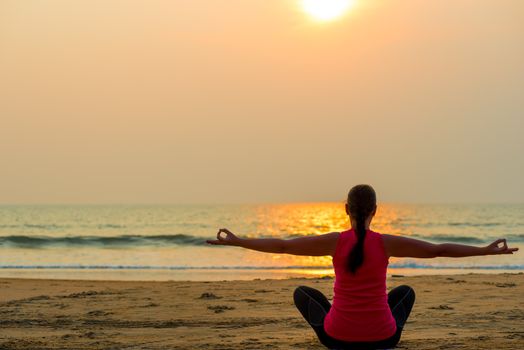 woman in the lotus position and setting sun