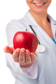 red ripe apple in the palm of a smiling doctor