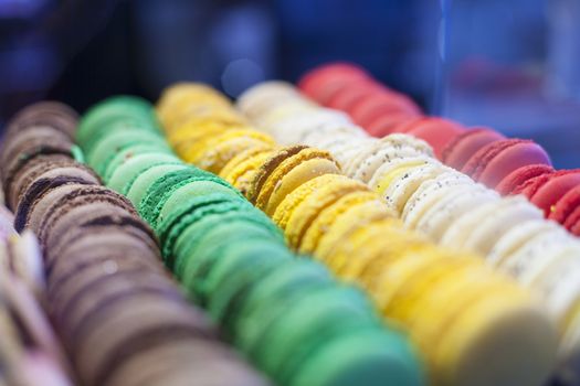 rows of color yellow green red brown macarons typical french cookies