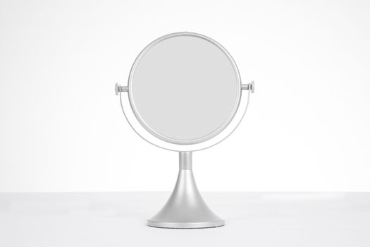 grey silver circular mirror for women makeup on table and white background