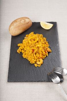 tapa of spanish paella on black slate plate