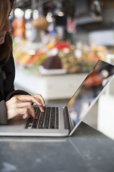 woman hands typing in keyboard laptop blank screen in a public market