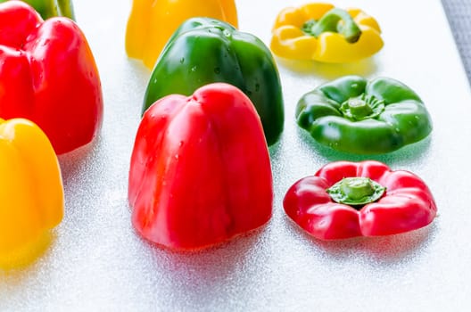 Yellow, Red, Green Bell Pepper cut on a silver platter.