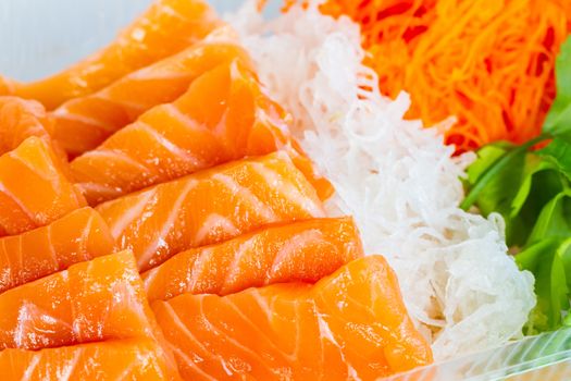 extreme close-up orange salmon fish cut with slices with vegetables