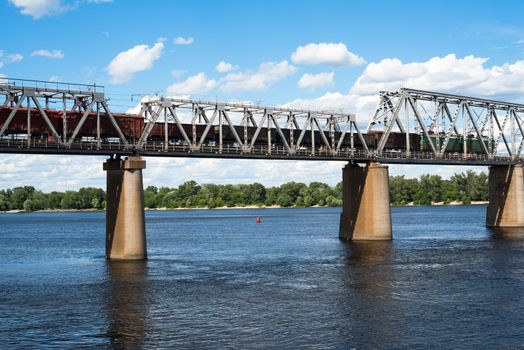 Petrivskiy railroad bridge in Kyiv across the Dnieper with freight train on it.