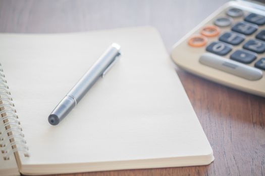 Blank notebook with pen on wooden table, stock photo