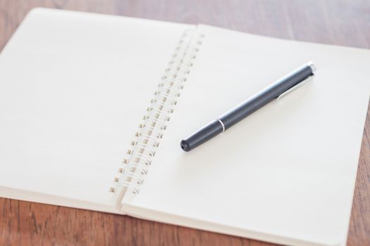 Blank notebook with pen on wooden table, stock photo