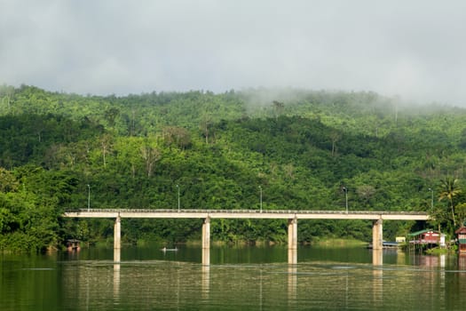 Bridge across river with mountain and fog