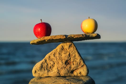 Balancing of apples on the top of triangle stone