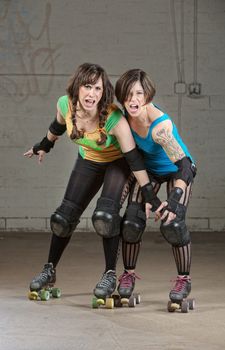 Aggressive women roller derby skaters threatening with a pose
