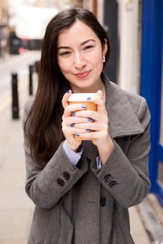 young woman holding a take away coffee