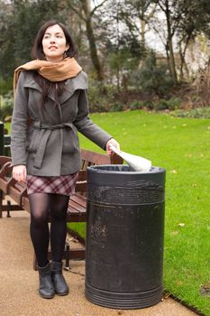 young woman throwing rubbish in the bin