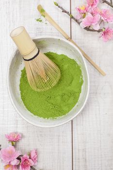 Still life with green matcha tea powder and bamboo whisk. Japanese Tea Ceremony: Preparation of matcha powdered green tea